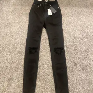 Svarta high waisted jeans med hål därframme. Aldrig använt köpte för 200 säljer för 100 köparen står för frakten.