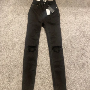 Skinny jeans svarta  - Svarta high waisted jeans med hål därframme. Aldrig använt köpte för 200 säljer för 100 köparen står för frakten.