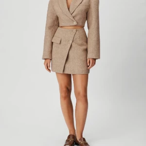 Croppad kavaj från Adoore - Beige kavaj från Adoore i storlek 32 (storlek slutsåld på hemsidan). Säljer då den är för liten. Helt ny med etiketterna kvar. Nypris: 1595 kr