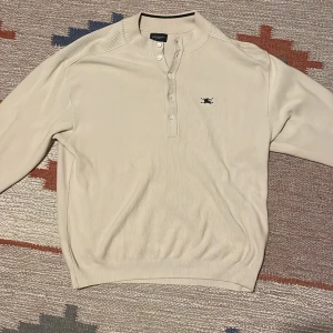 Stickad Burberry tröja - Stickad burberry tröja med knappar. Köpt second-hand. Mycket bra passform på mig som är 178 men materialet är väldigt flexibelt