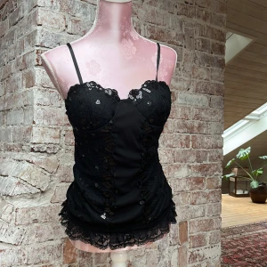 Topp  - Topp med paljetter och lite vaddering i kuporna! Finns öglor som man kan fästa band i midjan🖤 står inte storlek men sitter som S/M