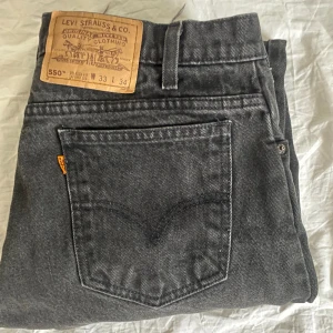 Levis 550 - Tja! Säljer dessa svarta ”orange label” Levis 550 med en distressed/ stentvättad look. De har en rakare eller lite mer relaxed passform och är avklippta nedtill, passar mer likt 32/32.