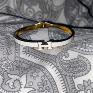 Ett jätte fint vit och guldigt armbande med ett H på. Den är i ett mycket bra skick då den bara är använd ett fåtal gånger.💕