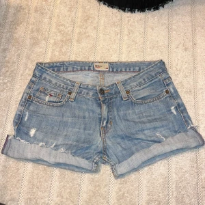 Lågmidjade Tommy Hilfiger shorts  - Snygga shorts från Tommy Hilfiger denim med låg midja. Bra skick! Det har tidigare varit ett par jeans men jag klippte av dem till shorts.  Tyvärr har jag vuxit ur dem så kan inte visa hur dem sitter på 