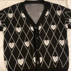 Säljer en oversized svart o vit cardigan med hjärt mönster som inte används💕 skriv om ni har frågor och priset går definitivt att diskutera 