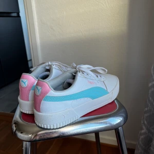 Söta vita Puma sneakers - Vita sneakers från puma med fina rosa och blå detaljer, väldigt sparsamt använda. Supergulliga och sköna men lite för små för mig (lutar själv mer mot strl 40 i skor)! Pris kan diskuteras och fler bilder kan skickas!💗