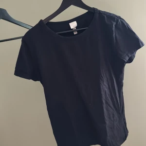 Svart T-shirt  - Svart T-shirt från H&M. Storlek L figurnära passform. Använt men gott skick