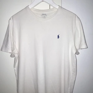 Vit Ralph Lauren t-Shirt - Vit Ralph Lauren tisha i strl M, endast en liten prick som ända deffekt på tishan (se bild)  