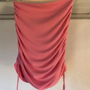 Rosa kort kjol från Zara med schrunchi detaljer och snören nedtill. Försluts med dragkedja baktill. Aldrig använd.