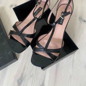  Sandaletter Tiger of Sweden  stl 37 - Fina sandaletter / skor med låg klack från Tiger of Sweden i storlek 37. Svarta i lack. Endast använda vid ett par tillfällen. 