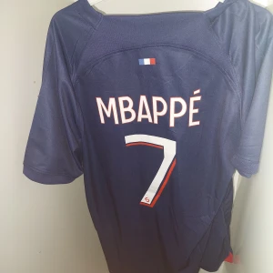 PSG Tröja, Mbappé #7 - PSG Hemmatröja 🏆 2023/24 🏆 I nyskick 🏆 Mbappe, #7 🏆  För endast 449kr kan detta världskända matchställ bli ditt! Hör av dig vid funderingar.