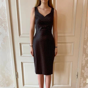 Svart mönstrad klänning, Emmy Design - Jätteskön klänning i väldigt stretchigt material. Storlek 36. Stor i storlek, passar 38. Modellen på bilden är 173 cm och har storlek 38 i de flesta andra kläder. Aldrig använd. Vi har lagt ner vår klänningsbutik och säljer ut. Ny pris är 2000-3000kr