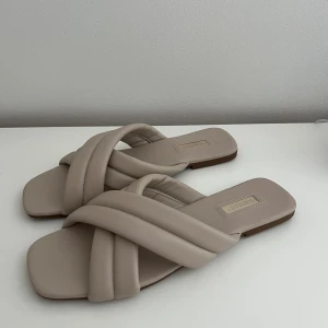 Beiga tofflor - Jättefina skor perfekt till sommaren!! Färgen visar sig inte riktigt rätt på de två första bilderna utan de är me ljusa i verkligheten som man ser på den sista bilden, & de är i bra skick bortsett från några små skador längst fram vid tårna på skon!