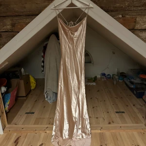 Balklänning  - Säljer en oanvänd balklänning med prislappen kvar. Den är ifrån nelly med en fin snörning i ryggen, storlek 40 men känns som en 38. 