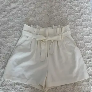 Vita kostym shorts med gullig rosett. Har endast använt den en gång.