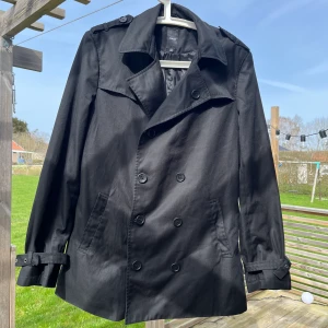 Trenchcoat - Trench från Emilio i storlek M. Saknar en knapp på axeln och någon lös, se bild. Jag är 176 och väger 75. Funkar säkert för +-5 kg.