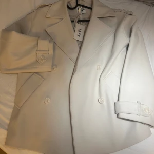 ✨Naturvit kappa ✨ - Super fin Naturvit kappa från NA-KD ✨ Tyvärr var den lite för stor för mig och därför har jag bestämt mig att sälja den. Original priset är 999 SEK , om ni skulle vilja ha fler bilder eller mer information gällande kappan kan ni gärna höra av er . ✨