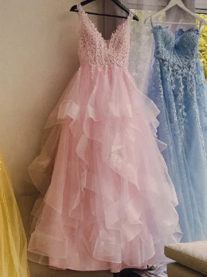 Ljusrosa balklänning - Drömmig ljusrosa balklänning med flera lager volang och spetsdetaljer upptill. Klänningen har v-ringning och smala axelband, och är fluffig vilket ger en riktigt sagolik känsla!!💗💗💗 Endast använts 1 gång!!! 
