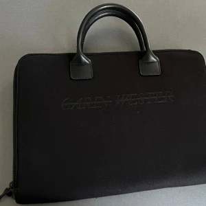 Svart datorväska Carin Wester - Stilren svart datorväska från Carin Wester. Väskan har handtag. Perfekt för att bära din laptop på ett snyggt sätt.