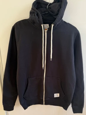 Premium Hoodie - Snygg och stilren hoodie i kraftigt sweatshirtmaterial. 60% bomull och 40% polyester, med dragkedja, huva med dragsko och praktiska fickor. Materialet känns riktigt gediget och exklusivt. Säljer den endast eftersom jag har insett att jag inte använder den så mycket som jag trodde. Väldigt fin hoodie som förtjänar att komma till någon som faktiskt kommer använda den. 
