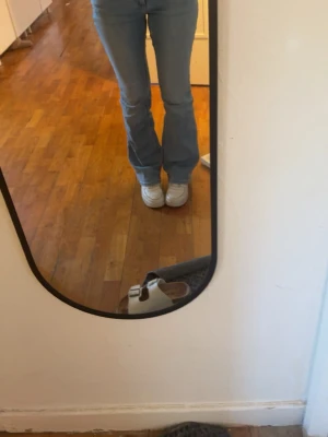 Ljusblå bootcut jeans - Säljer ett par ljusblå bootcut jeans med hög midja och klassiska fem fickor. Jeansen har en snygg utsvängd passform från knät och är tillverkade i mjukt denimtyg. Perfekta för en avslappnad och trendig look. Det är storlek xs i midja och 32 längd 