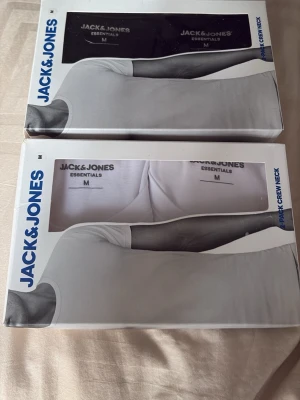 Jack & Jones Essentials T-shirts 2-pack - Säljer två oöppnade 2-pack vita och/eller svarta t-shirts från Jack & Jones. Båda paketen är i storlek M. På mig som är 183cm lång och väger 74kg sitter tröjorna bra då jag jämför med en annan tröja jag själv äger fast i samma modell på bild 4. Bra investering med nya fräscha t shirts till ett bra pris. 199kr för båda boxarna. 129kr om man vill köpa en box separat. Hör av dig vid minsta fundering!💫