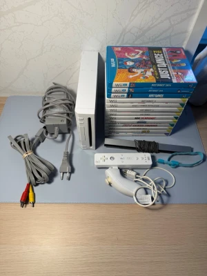 Nintendo Wii med tillbehör och spel - Nintendo Wii i vit färg med originalkontroll, nunchuk, sensorbar, strömadapter, AV-kabel och flera spel, bland annat Just Dance-serien, NHL Slapshot och ATV Quad Kings. Perfekt för dig som gillar partyspel och rörelsebaserade spelupplevelser.