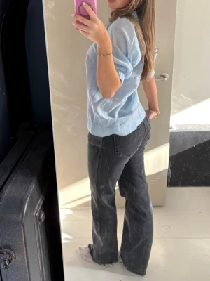 Mörkgråa raka jeans med medelhög midja - Säljer ett par svarta jeans med rak passform och hög midja. Jeansen har klassisk femficksdesign och är tillverkade i ett kraftigare denimtyg. Perfekta för en avslappnad och trendig look.