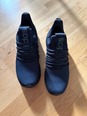 Adidas sneakers  - Snygga adidas sneakers med sportig vibe och tydlig textdetalj på plösen. Skorna har rund tå, mesh-liknande ovandel och breda svarta snören. Sulan är svart och ger ett stilrent helhetsintryck. Perfekta för en streetwear-look.