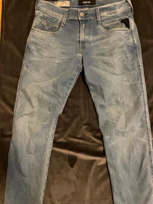 Replay jeans  - Snygga blå slim fit jeans från Replay med klassisk femficksmodell och ljusa slitningar. Jeansen har normal midja, dragkedjegylf och detaljerade sömmar på bakfickorna. Tillverkade i mjuk denim för skön passform.
