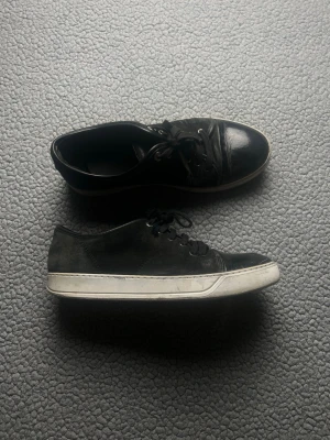 Svarta låga sneakers med vit sula - Lanvin skor, haft de ett tag. Slitna, därav det billiga priset. Se bilderna. Defektera påverkar ej användningen.
