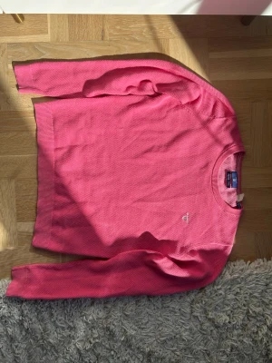 Rosa stickad tröja från gant  - En fin rosa tröja. Tröjan är perfekt nu till hösten för den är lite tunnare än en tjocktröja. Färgen på tröjan är perfekt för att fixa upp en ”tråkig” outfit. 