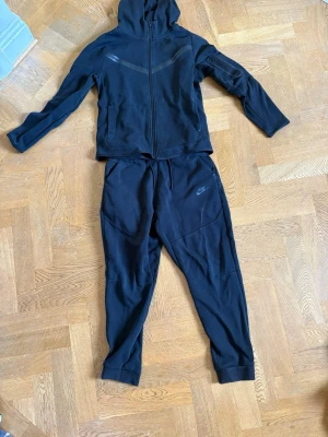 Svarta overall från Nike  - Säljer ett par svarta mjukisbyxor från Nike med avslappnad passform och resår i midjan. Byxorna har diskret Nike-logga på benet och muddar vid bensluten. Perfekta för chill dagar eller träning. Materialet är mjukt och bekvämt. Skriv vid minsta fundering och priset är inte hugget i sten 