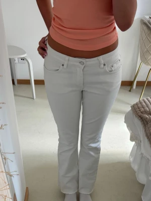 Vita bootcut jeans med låg midja - Säljer ett par vita jeans med bootcut-modell och låg midja. Jeansen har klassiska fem fickor och är tillverkade i ett stretchigt denimtyg som sitter snyggt på kroppen. Perfekta för dig som gillar en clean och fräsch look. Säljer då de är några cm för korta på mig som är 166 och har väldigt långa ben💕
