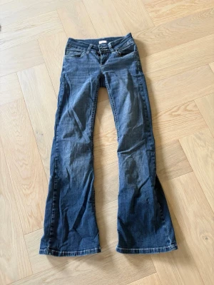 Blå bootcut jeans från Nelly - Säljer ett par blå bootcut jeans från Nelly med snygga broderade detaljer på bakfickorna. Jeansen har klassisk femficksmodell, normal midja och är tillverkade i denim. 