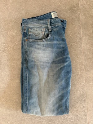 Ljus Blå Replay Anbass jeans  - Säljer ett par blå Replay Anbass jeans i bra skick som är tjocka och lite tåligare. Dem är i storlek 34/32 men omsydda i midjan till 31/32 så perfekt till dig som inte vill ha supertajta byxor.  Skriv vid minsta lilla fundering, priset är inte fast. 