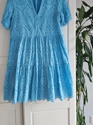 Blå klänning från Y.A.S - Supersöt blå klänning från Y.A.S med broderade detaljer och v-ringning. Klänningen har korta ärmar och volangkant nertill. Anv fåtal ggr. 