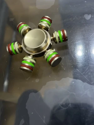 Metall fidget spinner med färgade ringar - Säljer en tung fidget spinner i metall med sex armar. Varje arm har ringar i grönt, rött och svart som ger en cool look. Spinnern är rund och har en borstad finish i guldton. Perfekt för dig som gillar att pilla med något när du pluggar eller chillar.
