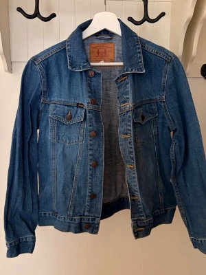 Blå jeansjacka från Crocker - Klassisk blå jeansjacka från Crocker. Tidlös design som passar till det mesta. Köpt second hand men inte kommit till användning, minimalt slitage. Skriv till mig om du har några frågor💙