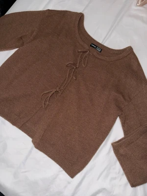 Brun stickad cardigan med knytband - Mysig brun stickad cardigan från SHEIN med trendiga knytband framtill. Tröjan har rund halsringning, långa ärmar och en rak, något kortare passform. Perfekt för lager på lager och enkel att styla till olika outfits.