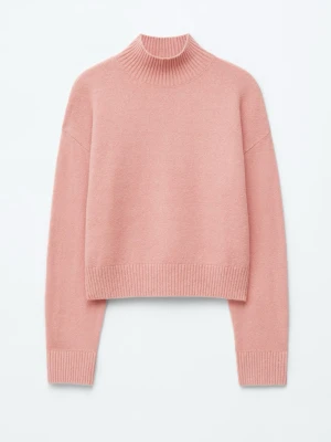 Rosa stickad tröja med hög krage -  rosa stickad tröja med hög ribbad krage och breda muddar vid ärmslut och nederkant. Den är i bra skick men är nopprig