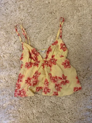 Blommig topp - Säljer denna toppen från subdued med blommigt mönster! Använd fåtal gånger, inga defekter. Den har justerbara axelband. Säljer då den inte kommer till användning. Storlek XS