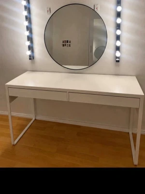 Rund sminkspegel med LED-belysning - Stilren rund sminkspegel med två rader LED-lampor på vardera sida för perfekt belysning. Spegeln har en modern design och passar perfekt till sminkbordet. Ramen är tunn och svart, vilket ger en minimalistisk look. Perfekt för dig som vill ha bra ljus när du sminkar dig.