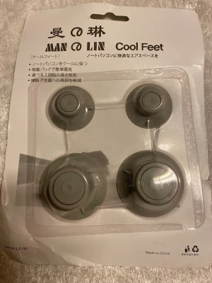 Cool Feet laptopfötter  - Säljer ett set med fyra gråa laptopfötter, perfekta för att höja din laptop och förbättra luftflödet under datorn. Tillverkade i plast och enkla att fästa under datorn för bättre kylning. Passar de flesta laptops och är smidiga att ta med.