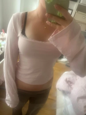 Ljusrosa långärmad topp med spets💗💗 - Söt ljusrosa långärmad topp från Gina tricot i storlek XS  med utsvängda ärmar och fyrkantig ringning dekorerad med spetskant och breda snören i ryggen som går att göra en rosset av. Toppen har en slim passform och är tillverkad i mjukt bomullsmaterial. Går att styla med det mesta. 