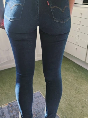 Mörkblå skinny jeans med hög midja - Säljer ett par mörkblå skinny jeans med hög midja och klassiska bakfickor. Jeansen har smal passform hela vägen ner och är tillverkade i stretchigt denimtyg för en bekväm känsla. Perfekta till sneakers eller boots!