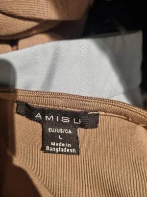 Beige ribbad topp från Amisu - Säljer en beige ribbad topp från Amisu med lång ärm och fyrkantig ringning. Toppen har en croppad passform och är tillverkad i ett mjukt material som sitter snyggt på kroppen. Perfekt att styla med jeans eller kjol.