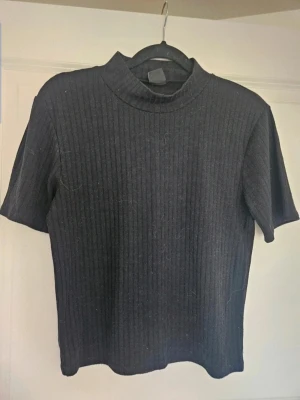 topp Gina Tricot M - Svart topp från Gina Tricot M  En svart ribbad topp från Gina Tricot i storlek M. Toppen har korta ärmar, högre halsringning och är tillverkad i ett mjukt, stretchigt material. Perfekt för en clean och stilren look.  Kan även hämtas I Partille  E1Svart topp från Gina Tricot M  En svart ribbad topp från Gina Tricot i storlek M. Toppen har korta ärmar, högre halsringning och är tillverkad i ett mjukt, stretchigt material. Perfekt för en clean och stilren look.  Kan även hämtas I Partille  E1