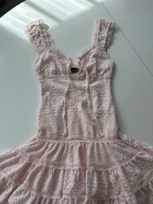 Ljusrosa spetsklänning Gina Tricot - Supersöt ljusrosa klänning från Gina Tricot i spets med volangdetaljer och snörning fram. Har bara andvänds en gång och säljer den eftersom att den är lite liten!💕