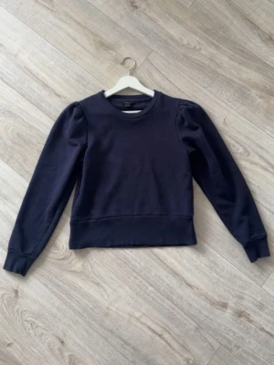 Sweatshirt Lindex - En fin blå sweatshirt från Lindex med lite puffiga armar, den börjar tyvärr bli för liten för mig. 💗
